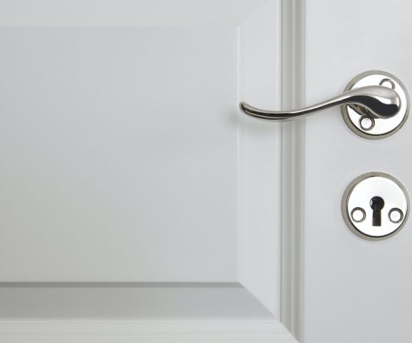 Metallic door knob on a classic white door. Home interior